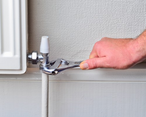 Plumber repairing a radiator pipe